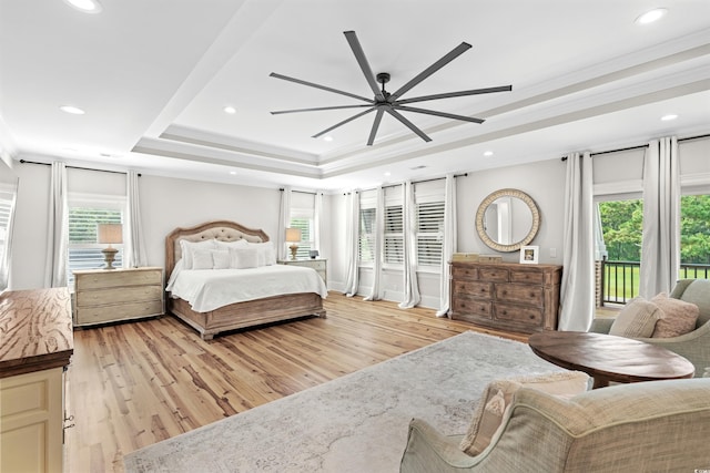 bedroom featuring light wood-type flooring, access to exterior, ceiling fan, and a raised ceiling