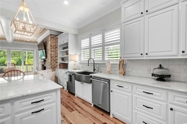 kitchen with white cabinets, hanging light fixtures, sink, dishwasher, and light wood-type flooring