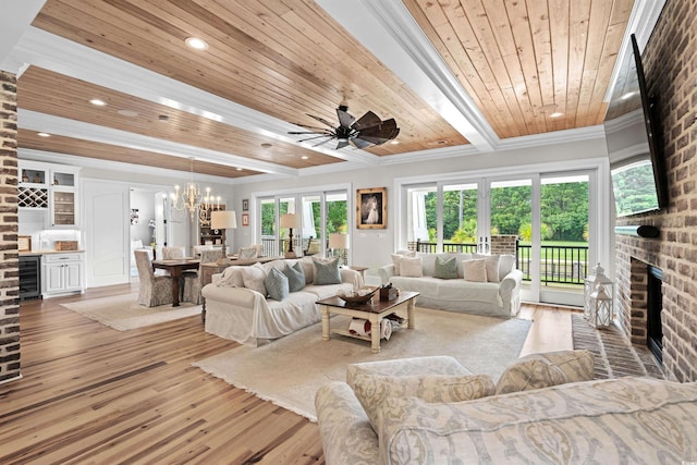 living room featuring wine cooler, wood-type flooring, a brick fireplace, wooden ceiling, and crown molding