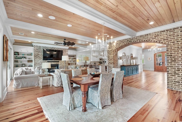 dining room with ornamental molding, light hardwood / wood-style flooring, a fireplace, and wood ceiling