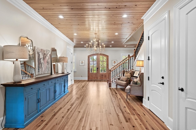 hallway featuring ornamental molding, french doors, light hardwood / wood-style flooring, wooden ceiling, and an inviting chandelier