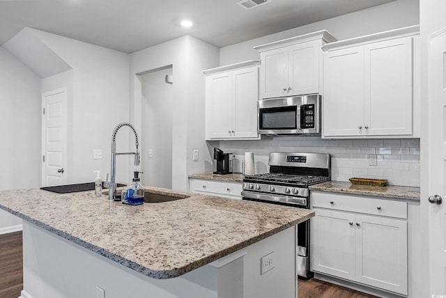 kitchen with white cabinetry, appliances with stainless steel finishes, and a center island with sink