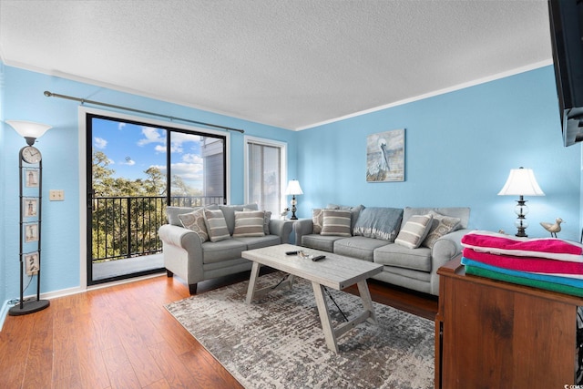 living room featuring crown molding, hardwood / wood-style floors, and a textured ceiling