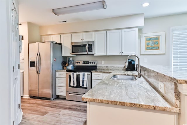 kitchen featuring white cabinets, light stone countertops, sink, and appliances with stainless steel finishes