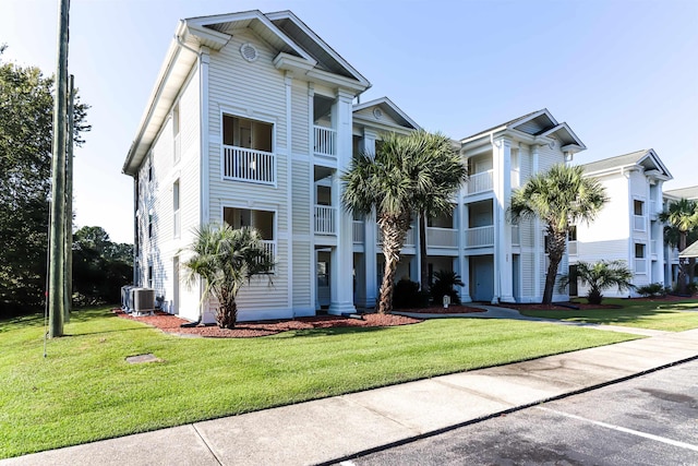 view of front of property with cooling unit and a front yard