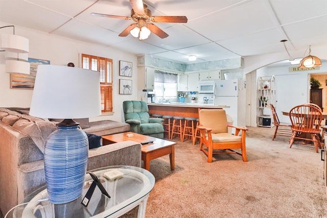 carpeted living room featuring a drop ceiling and ceiling fan