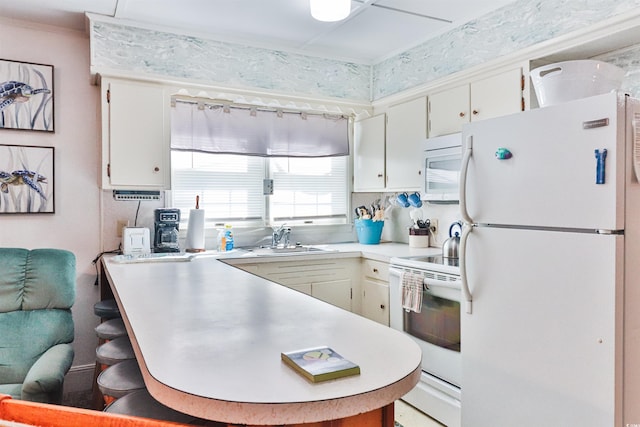 kitchen featuring kitchen peninsula, white cabinetry, white appliances, and sink