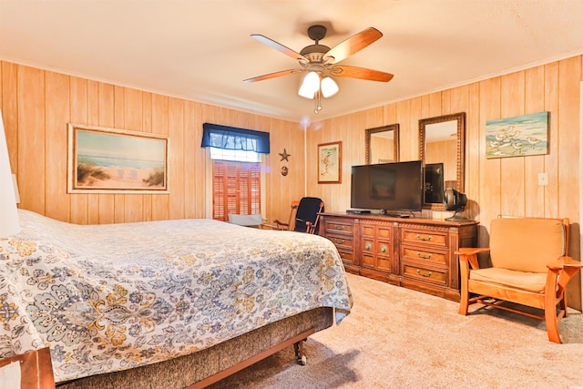 carpeted bedroom featuring crown molding, wooden walls, and ceiling fan