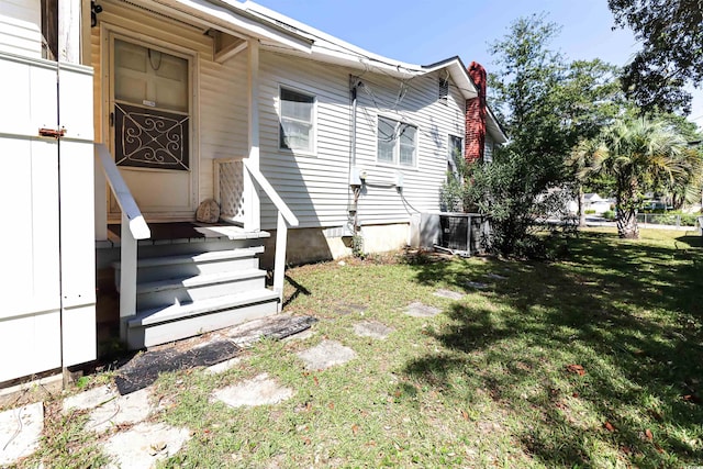 rear view of property with cooling unit and a yard