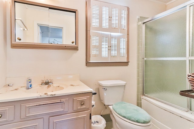 full bathroom with bath / shower combo with glass door, vanity, and toilet