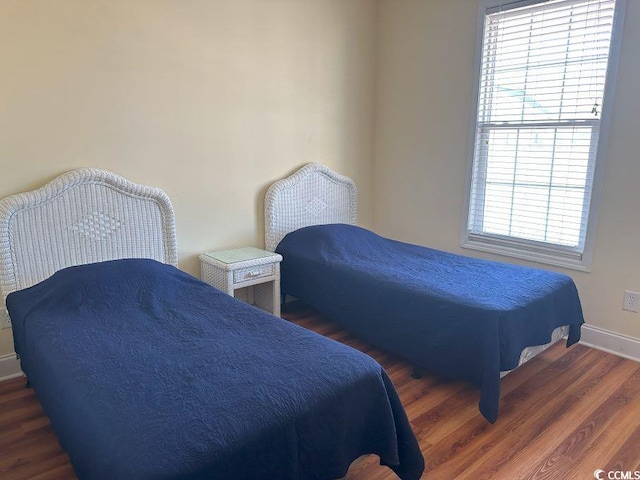 bedroom featuring dark hardwood / wood-style flooring and multiple windows