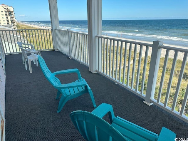 balcony featuring a beach view and a water view