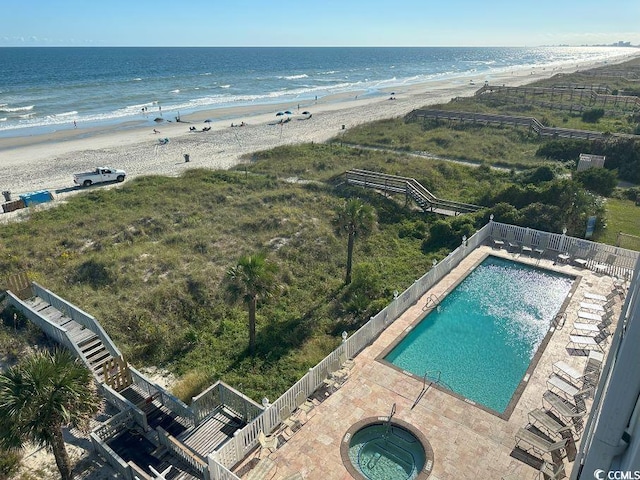 birds eye view of property with a water view and a view of the beach