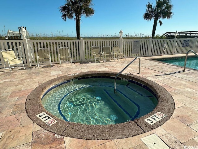 view of pool with a patio and a hot tub