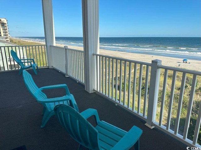 balcony with a water view and a beach view