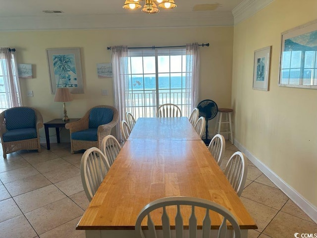 tiled dining area with an inviting chandelier, crown molding, and a water view