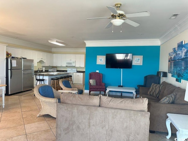 living room featuring crown molding, sink, light tile patterned floors, and ceiling fan