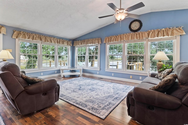 living room with a wealth of natural light, hardwood / wood-style flooring, and vaulted ceiling