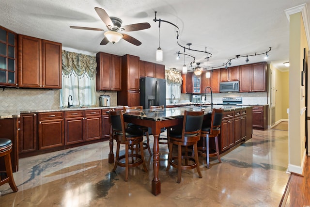 kitchen with light stone countertops, a breakfast bar area, backsplash, and appliances with stainless steel finishes