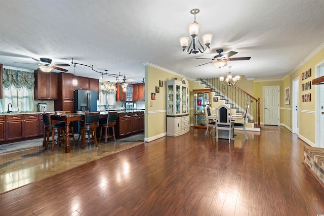 dining space featuring dark hardwood / wood-style flooring, an inviting chandelier, ornamental molding, and a textured ceiling