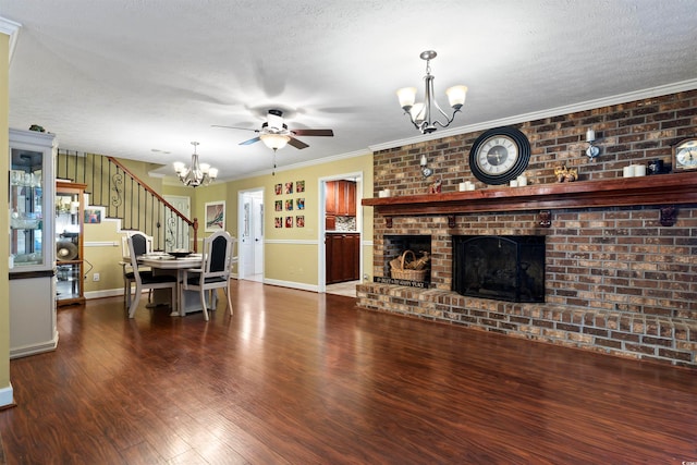 living room featuring a fireplace, crown molding, a textured ceiling, dark wood-type flooring, and ceiling fan