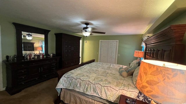 bedroom with a closet, a textured ceiling, dark colored carpet, and ceiling fan