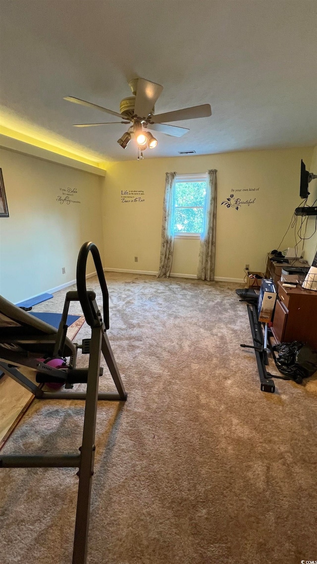 exercise area with ceiling fan and carpet flooring