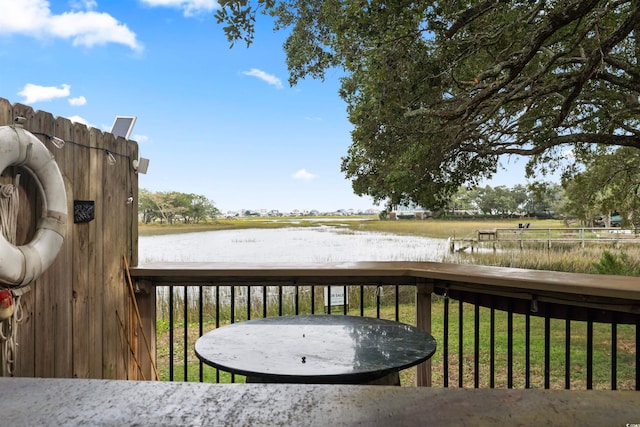 wooden deck with a lawn and a water view