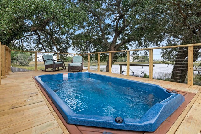 view of pool featuring a deck with water view