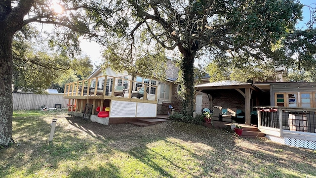 back of house featuring a deck and a lawn