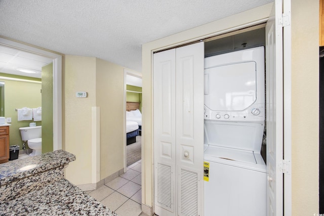 2301 Ocean Blvd S Unit 1218, Myrtle Beach, SC 29577 - washroom featuring stacked washer / dryer, light tile patterned floors, and a textured ceiling
