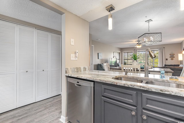 kitchen featuring sink, a textured ceiling, decorative light fixtures, light hardwood / wood-style flooring, and dishwasher