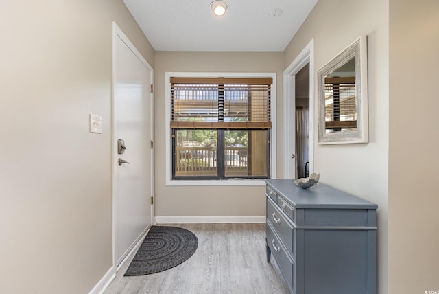 entryway with light wood-type flooring and a textured ceiling