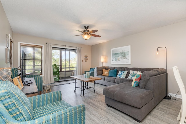 living room featuring ceiling fan, a textured ceiling, and hardwood / wood-style floors