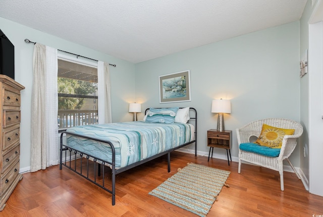 bedroom with wood-type flooring and a textured ceiling