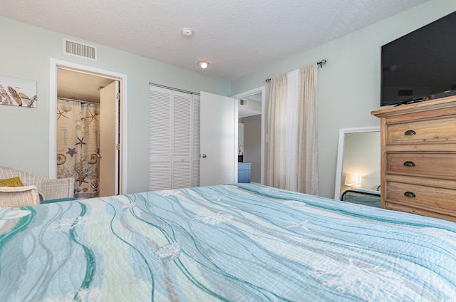 bedroom featuring a closet, connected bathroom, and a textured ceiling