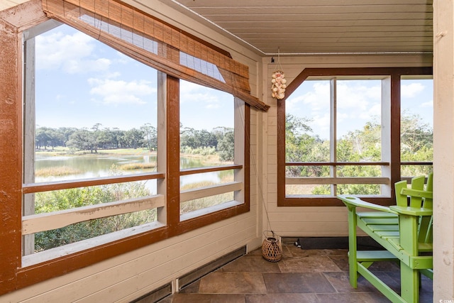 sunroom / solarium featuring a water view