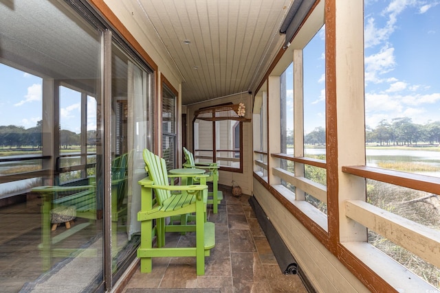 sunroom featuring a water view