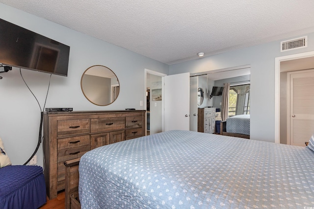 bedroom featuring wood-type flooring and a textured ceiling