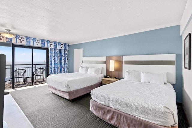 bedroom featuring a textured ceiling, a water view, ornamental molding, and access to exterior