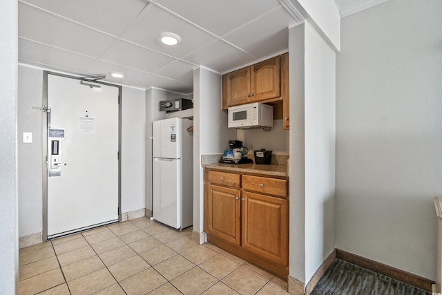 kitchen with white appliances and light tile patterned floors