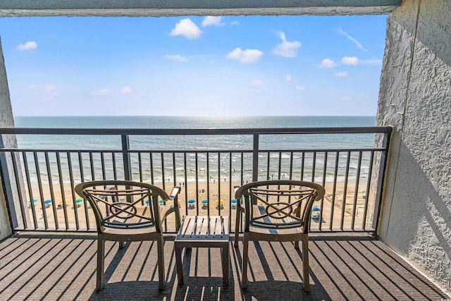 balcony featuring a beach view and a water view