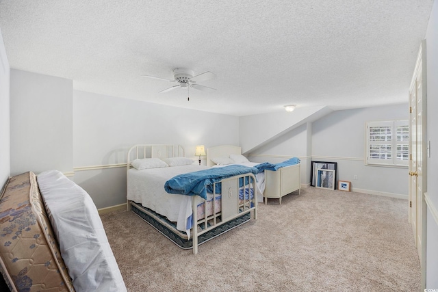 carpeted bedroom featuring baseboards, ceiling fan, and a textured ceiling