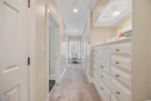 hallway featuring light colored carpet, ornamental molding, and baseboards