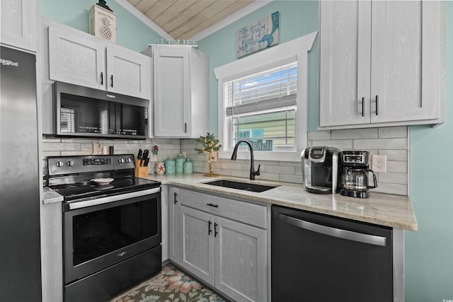 kitchen featuring sink, light stone counters, backsplash, white cabinets, and appliances with stainless steel finishes