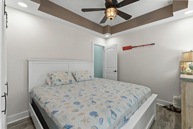 bedroom with dark hardwood / wood-style flooring and ceiling fan