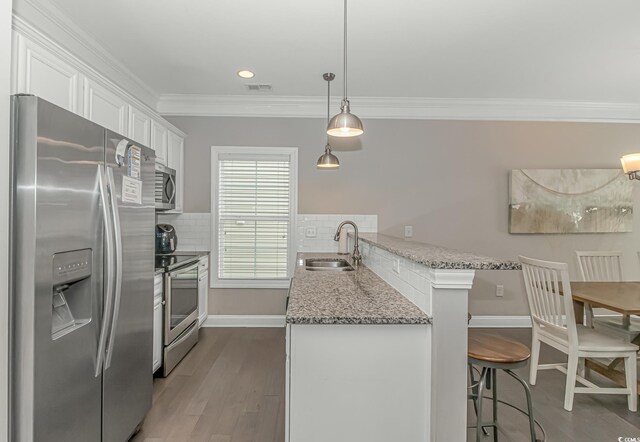 6001-MH32A S Kings Hwy, Myrtle Beach, SC 29575 - kitchen featuring pendant lighting, white cabinetry, sink, a kitchen breakfast bar, and stainless steel appliances