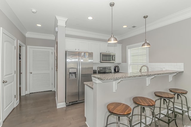 6001-MH32A S Kings Hwy, Myrtle Beach, SC 29575 - kitchen featuring light stone counters, appliances with stainless steel finishes, kitchen peninsula, decorative backsplash, and white cabinets