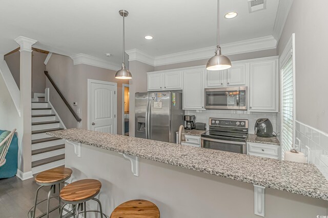 6001-MH32A S Kings Hwy, Myrtle Beach, SC 29575 - kitchen with white cabinetry, appliances with stainless steel finishes, a breakfast bar, and pendant lighting