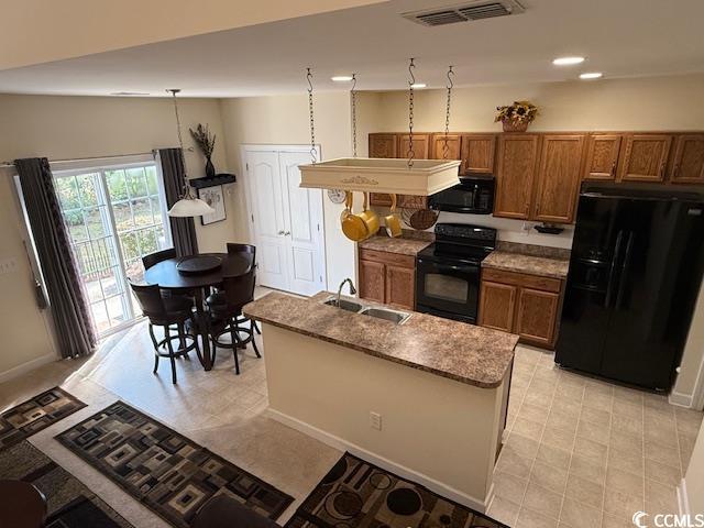 1188 Fairway Ln Unit 7, Conway, SC 29526 - kitchen with black appliances, brown cabinets, an island with sink, and recessed lighting